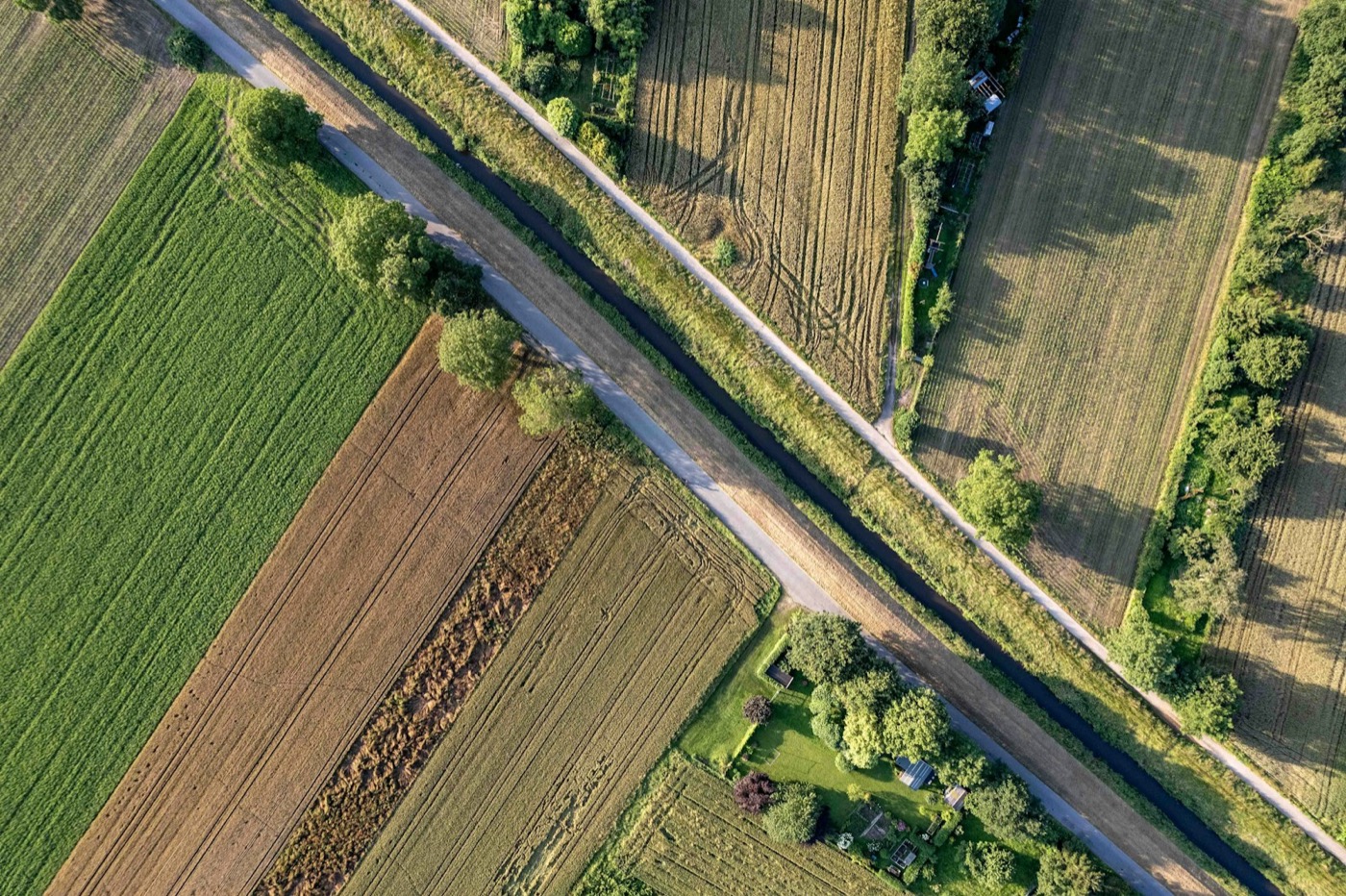Aerial view of fields, trees, roads, and nearby homes illustrating land and development context